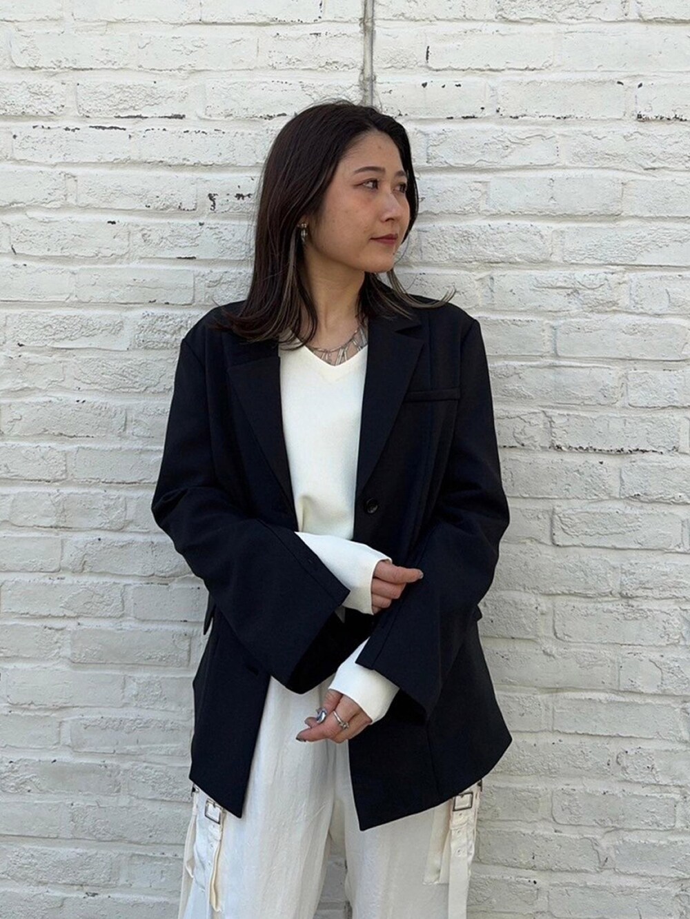 ブラック系のテーラードジャケットを着用したレディースの春コーディネートの5枚目の写真