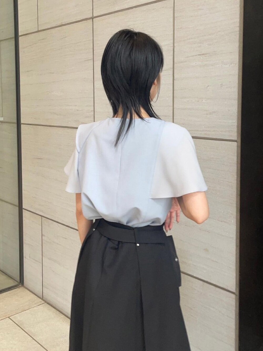 ブルー系のシャツ/ブラウス、ブラック系のスカートを着用したレディースの春コーディネートの6枚目の写真