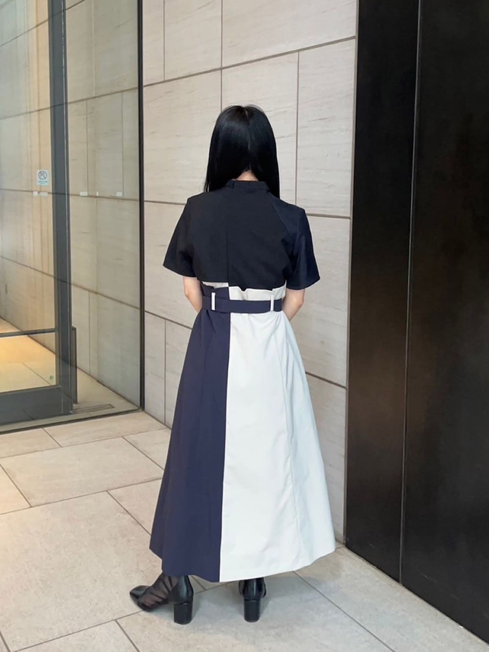 ブラック系のワンピースを着用したレディースの春コーディネートの3枚目の写真