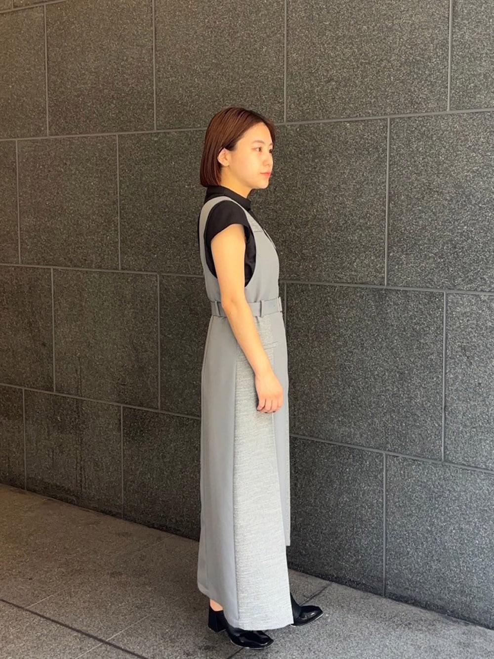 ブラック系のシャツ/ブラウス、グレー系のジャンパースカートを着用したレディースの夏コーディネートの3枚目の写真