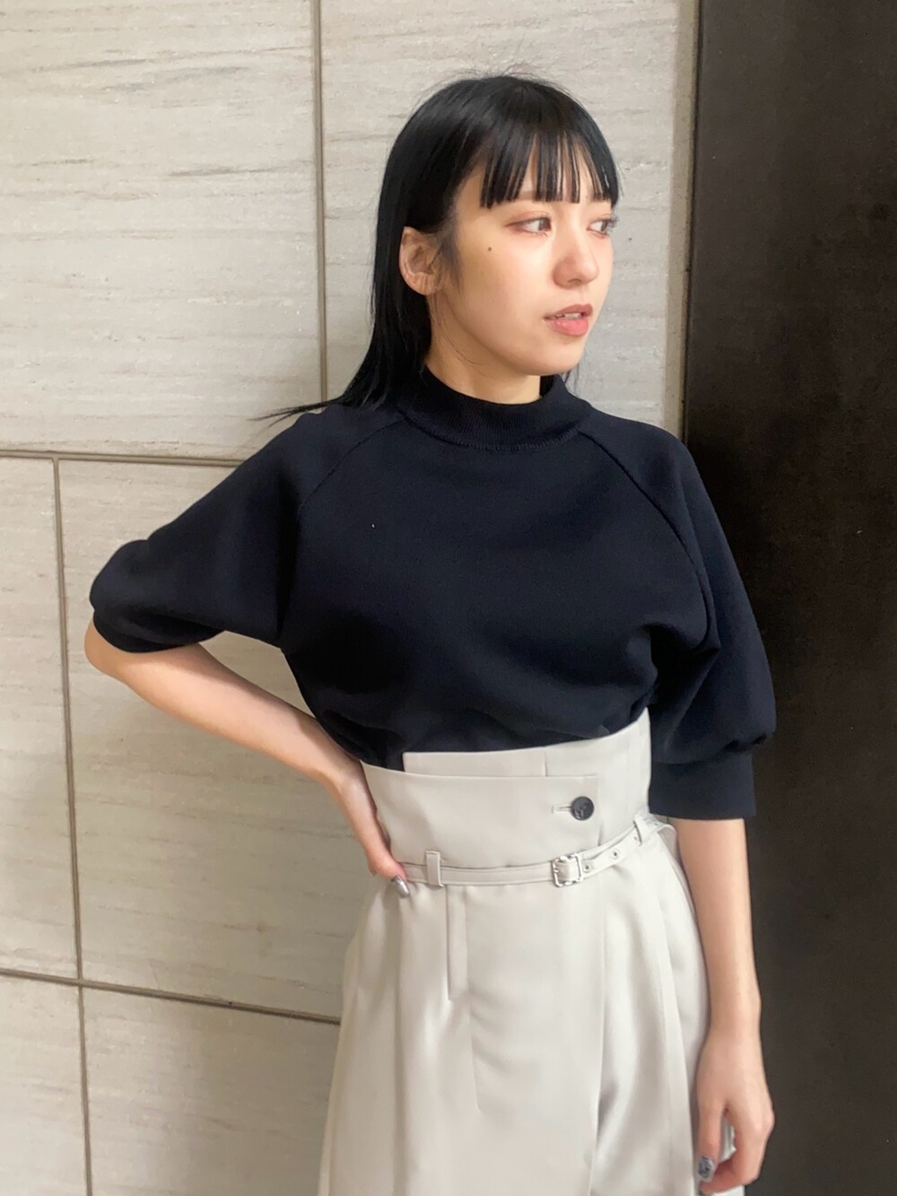 ブラック系のニット/セーター、グレー系のスラックスを着用したレディースの春コーディネートの3枚目の写真