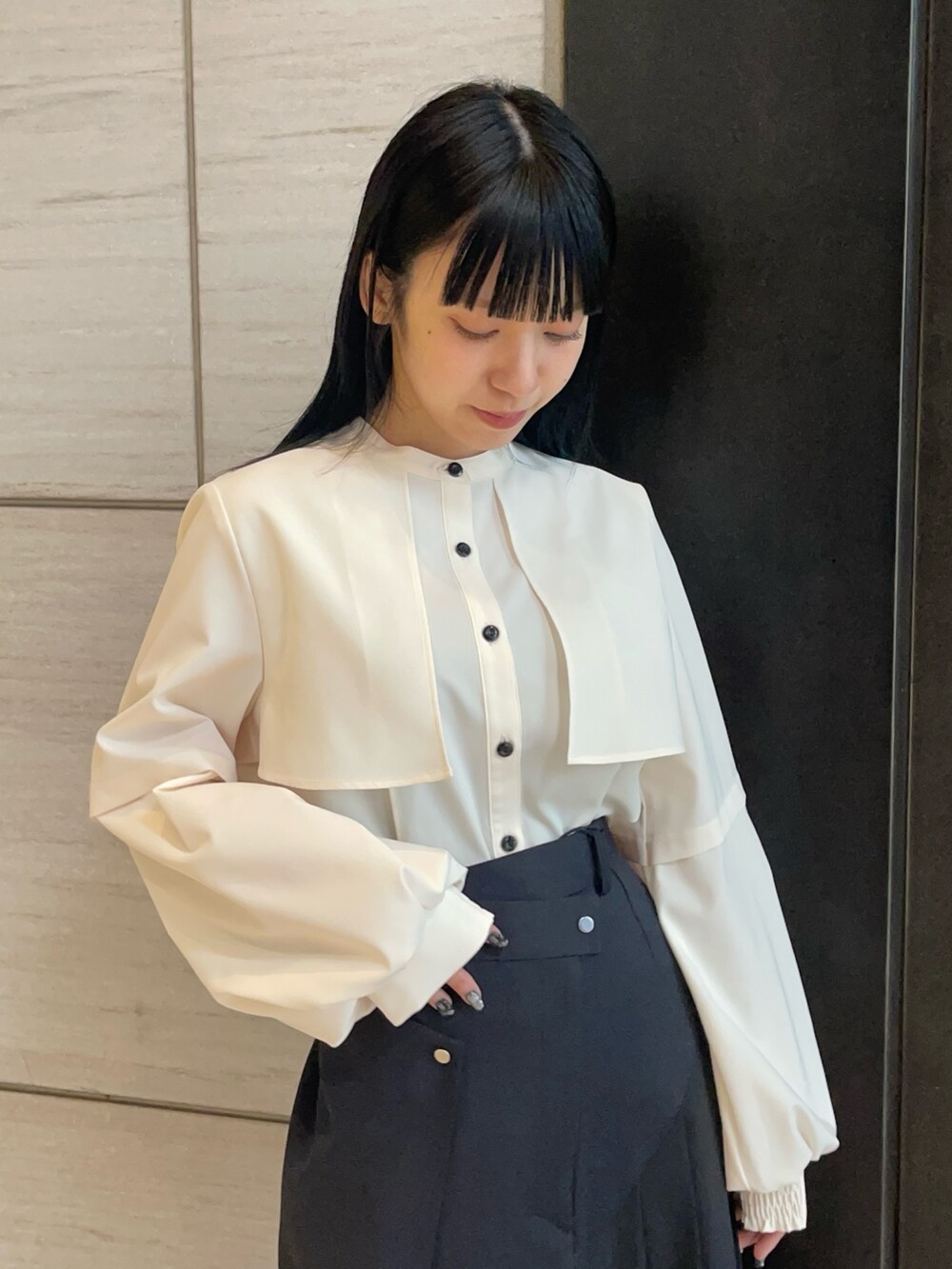 ベージュ系のシャツ/ブラウス、ブラック系のスカートを着用したレディースの春コーディネートの3枚目の写真