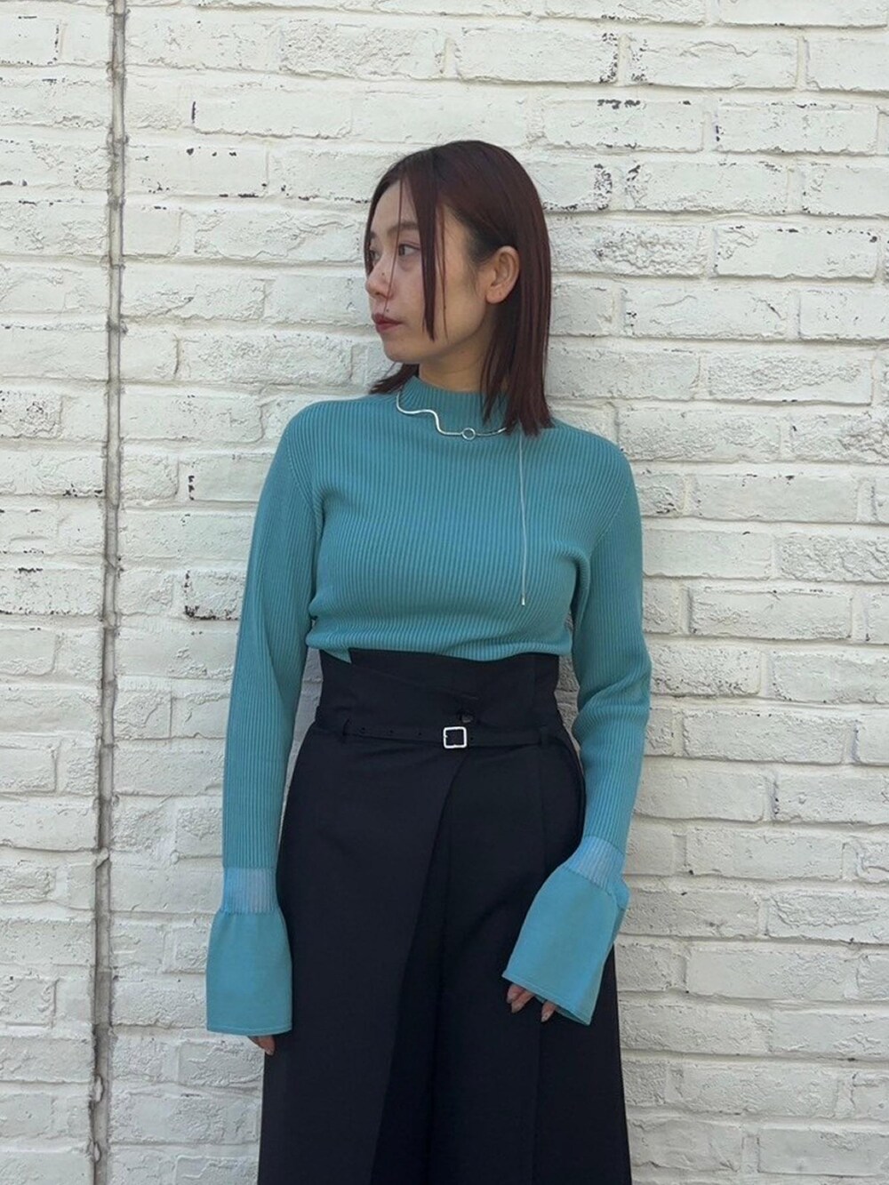 ブルー系のニット/セーター、ブラック系のスラックスを着用したレディースの春コーディネートの5枚目の写真