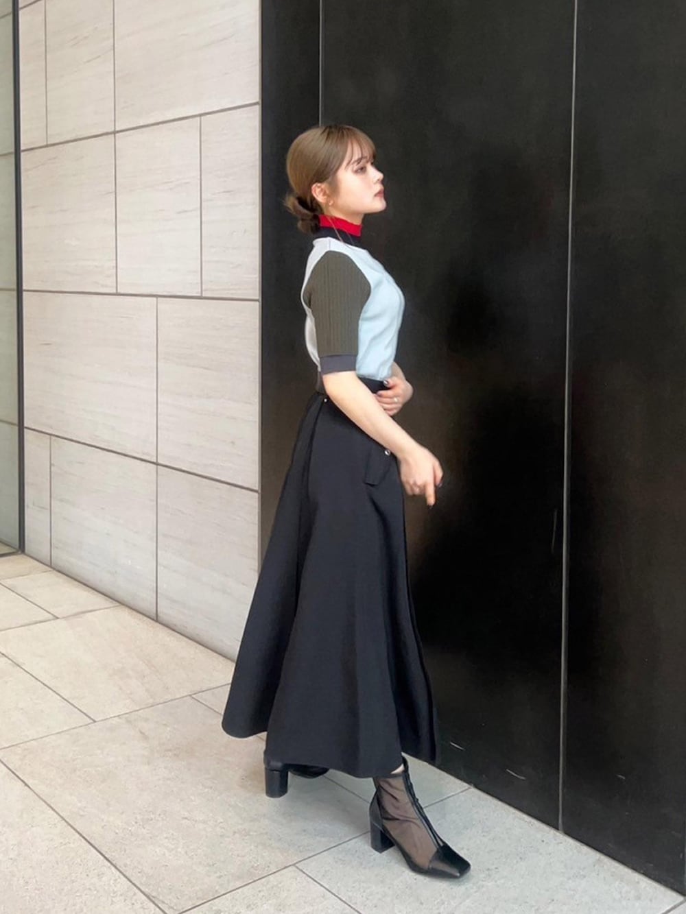 グレー系のニット/セーター、ブラック系のスカートを着用したレディースの春コーディネートの4枚目の写真