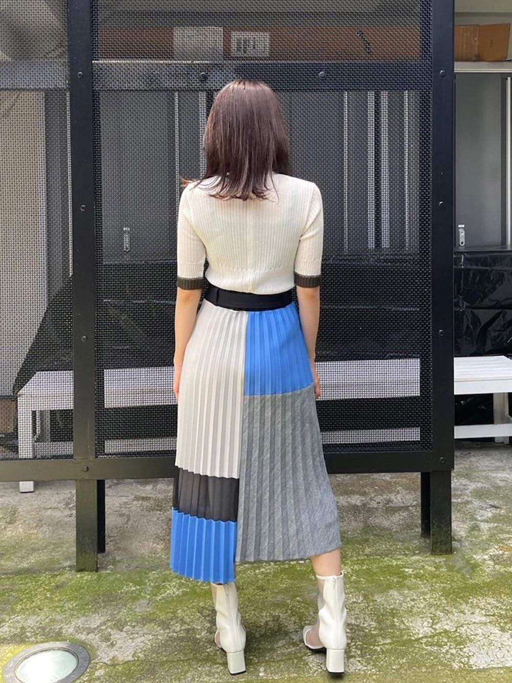ブルー系のスカート、ホワイト系のニット/セーターを着用したレディースの春コーディネートの3枚目の写真