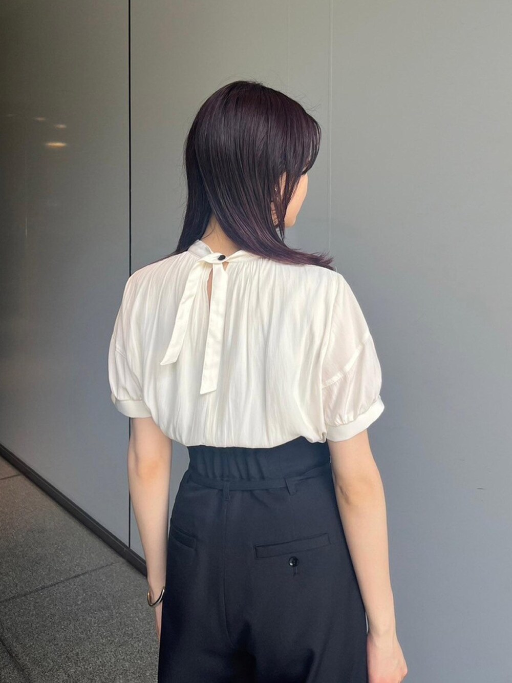 ベージュ系のシャツ/ブラウス、ブラック系のスラックス、ブラック系のサンダルを着用したレディースの夏コーディネートの4枚目の写真