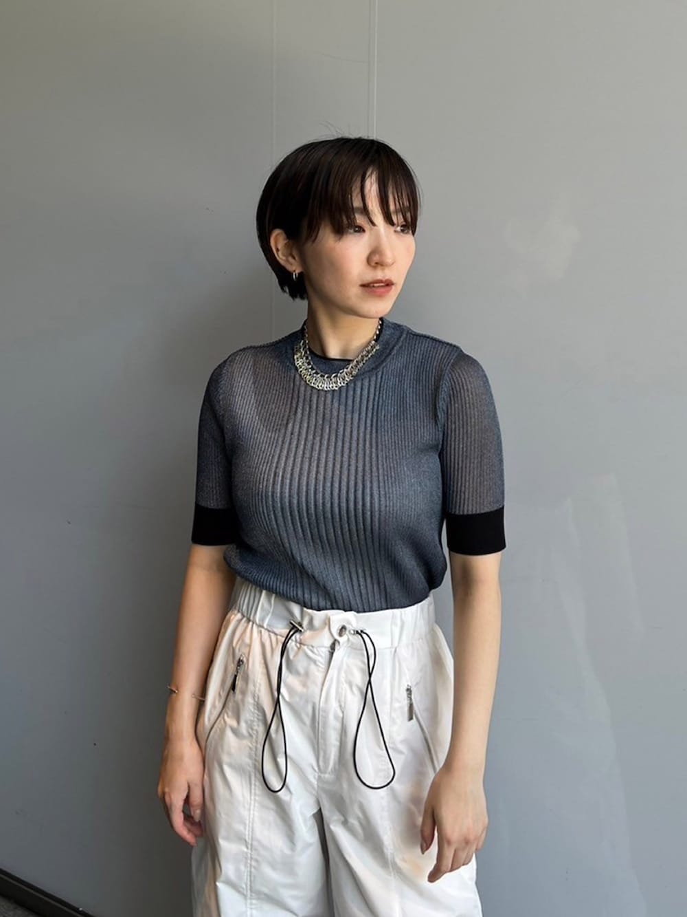 ブルー系のニット/セーター、ホワイト系のその他パンツを着用したレディースの夏コーディネートの3枚目の写真