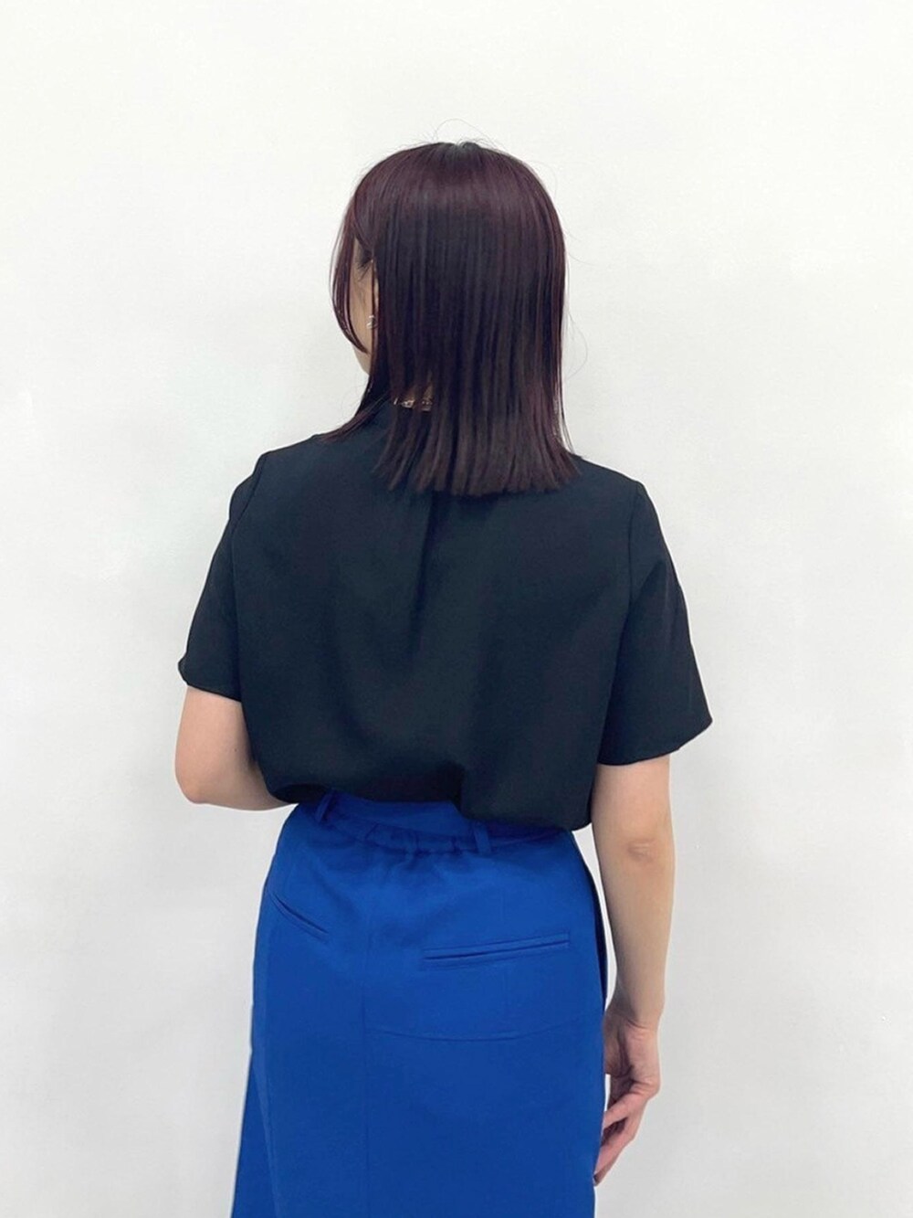 ブルー系のスカート、ブラック系のシャツ/ブラウスを着用したレディースの春コーディネートの6枚目の写真