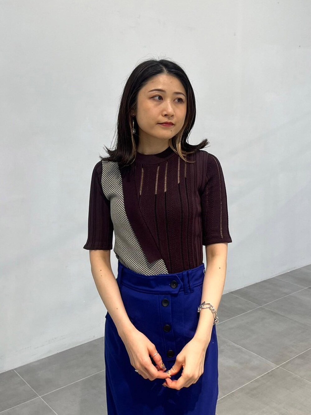 ブラウン系のニット/セーター、ブルー系のスカートを着用したレディースの秋コーディネートの4枚目の写真