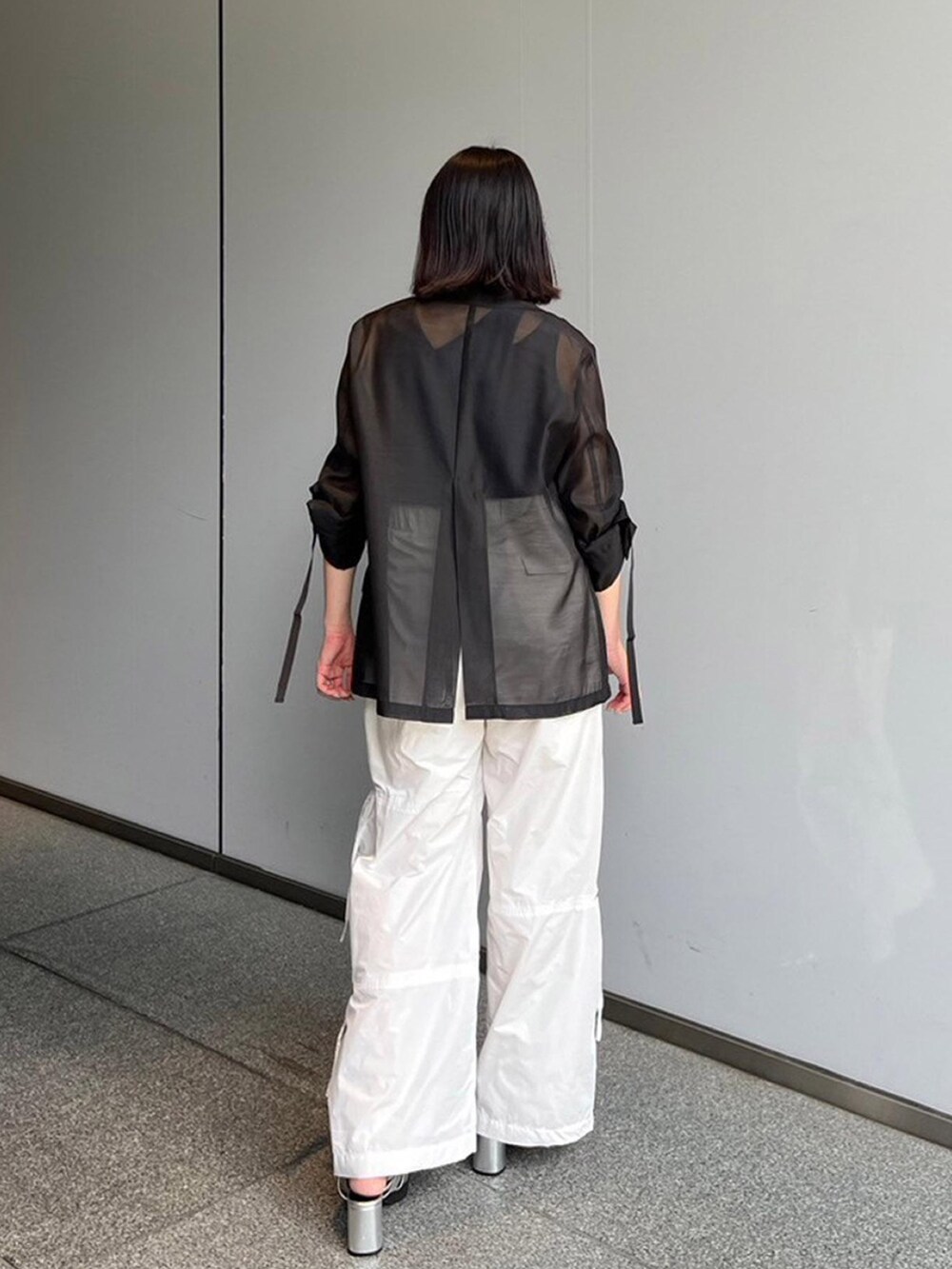 ブラック系のテーラードジャケット、ホワイト系のその他パンツ、ブルー系のタンクトップを着用したレディースの夏コーディネートの3枚目の写真