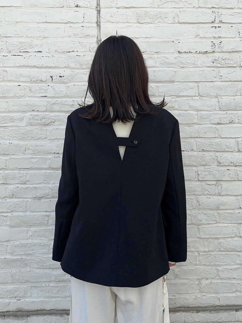 ブラック系のテーラードジャケットを着用したレディースの春コーディネートの6枚目の写真