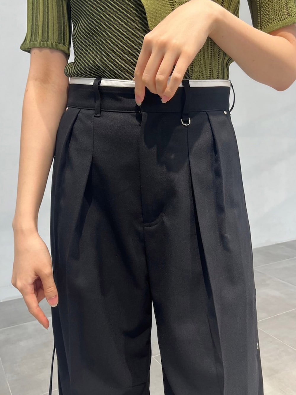 グリーン系のニット/セーター、ブラック系のその他パンツを着用したレディースの秋コーディネートの5枚目の写真