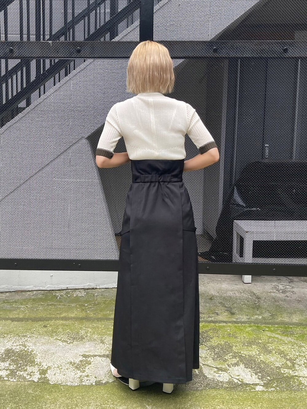 ホワイト系のニット/セーター、ブラック系のスカートを着用したレディースの夏コーディネートの3枚目の写真