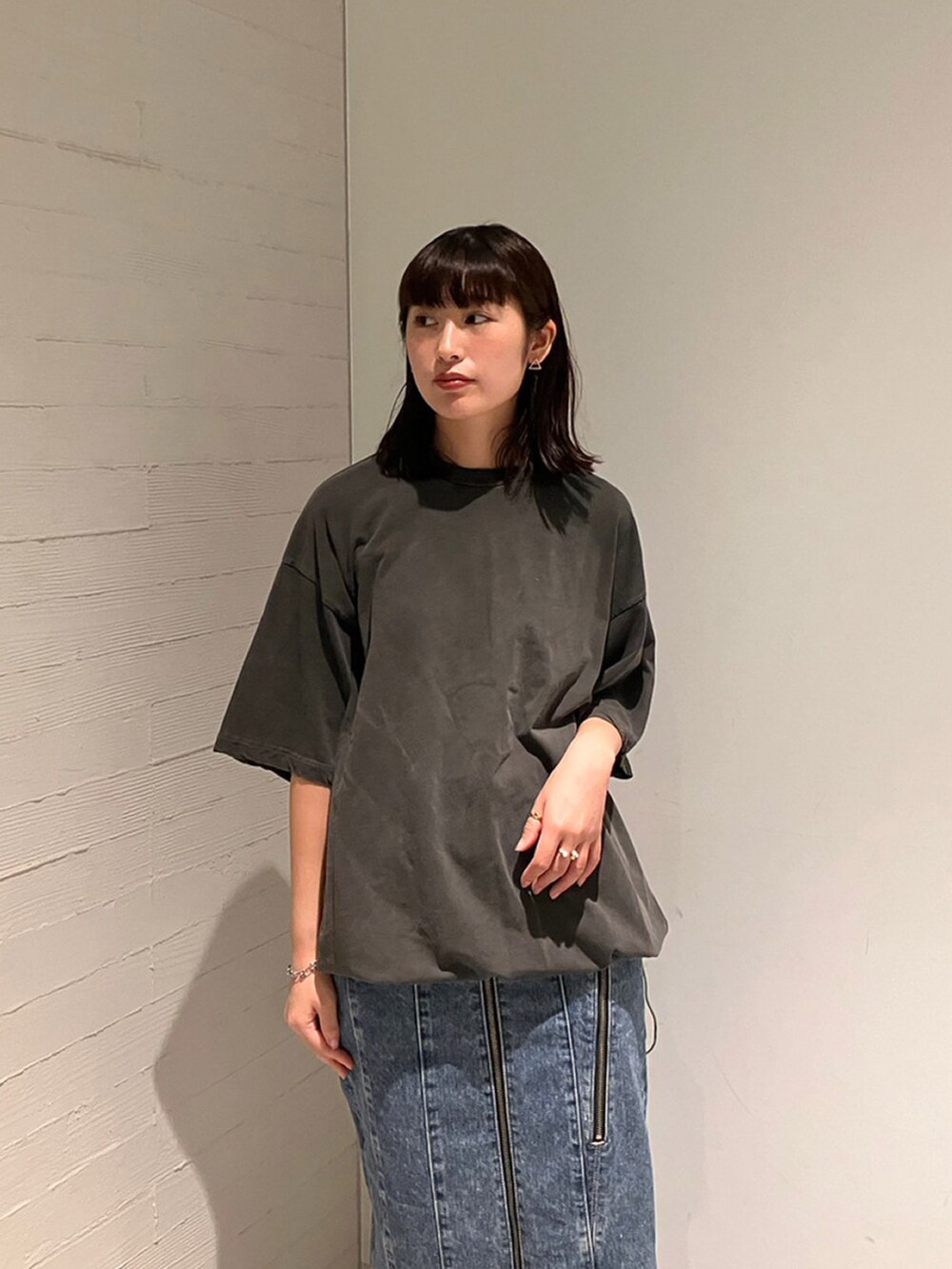 グレー系のTシャツ/カットソー、ブルー系のデニムスカートを着用したレディースの夏コーディネートの3枚目の写真