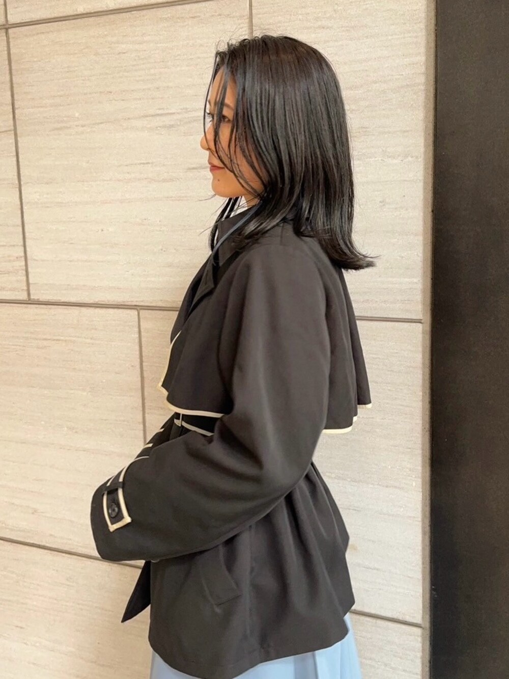 ブラック系のトレンチコートを着用したレディースの春コーディネートの5枚目の写真