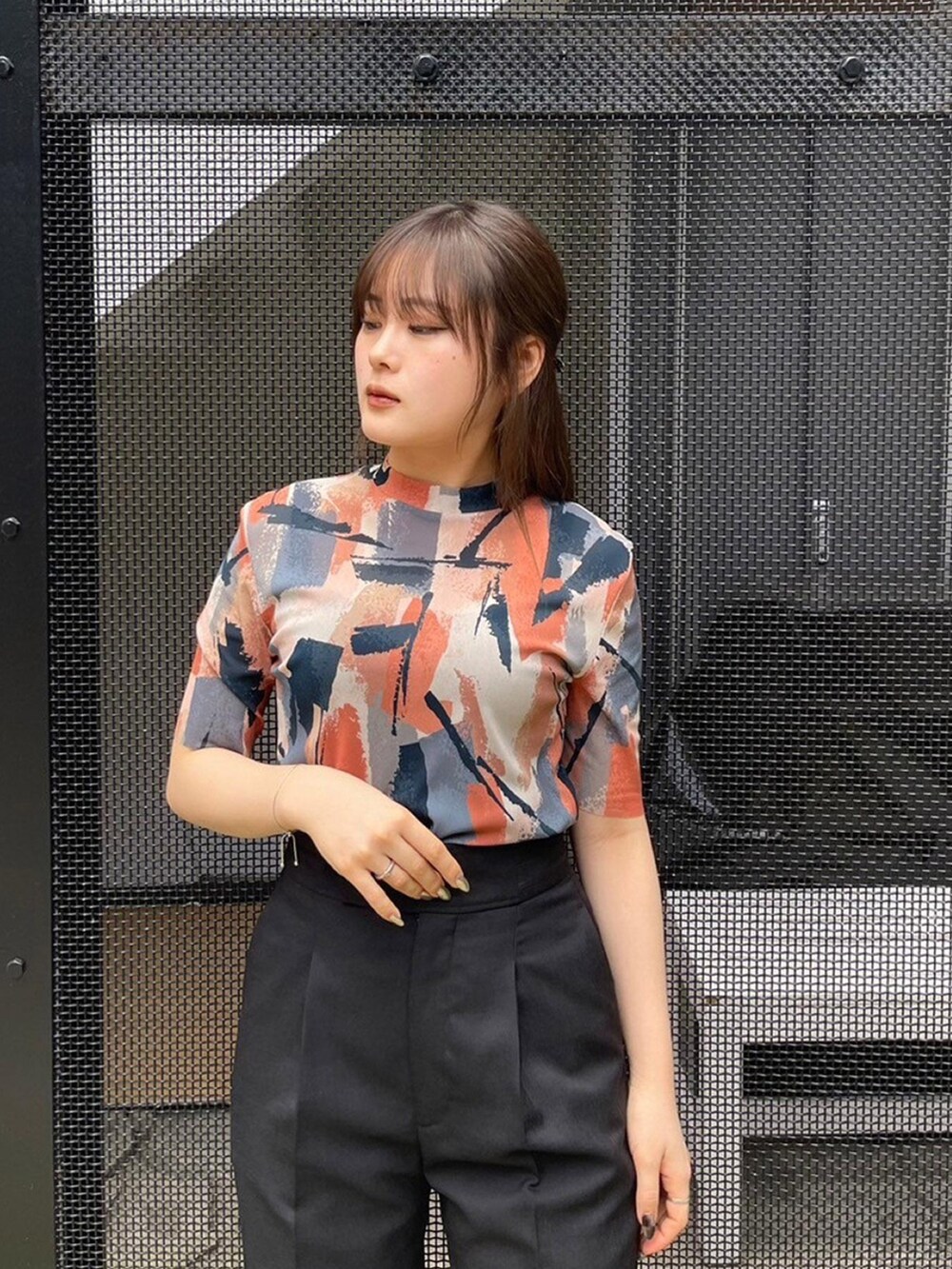 ベージュ系のTシャツ/カットソー、ブラック系のスラックスを着用したレディースの春コーディネートの5枚目の写真