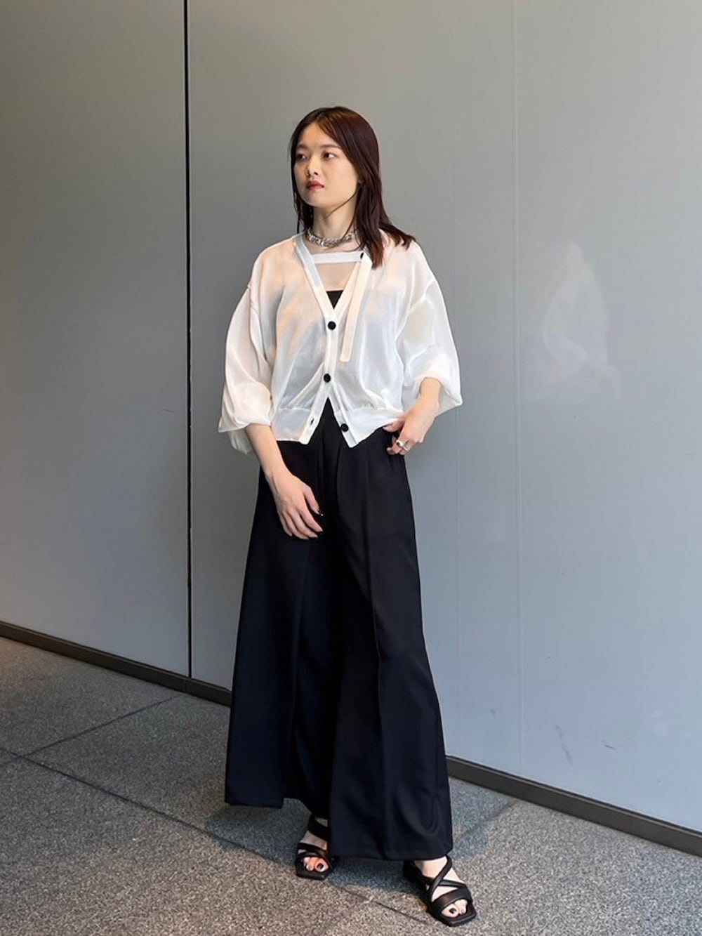 ホワイト系のカーディガン/ボレロ、ブラック系のスラックスを着用したレディースの夏コーディネートの2枚目の写真