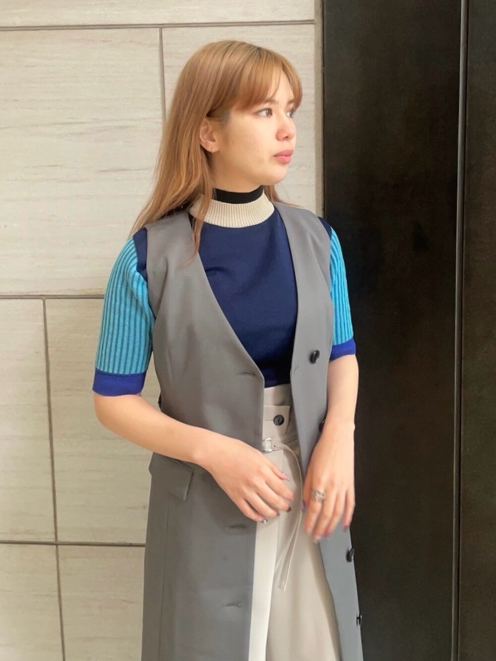 グレー系のジャンパースカートを着用したレディースの春コーディネートの4枚目の写真