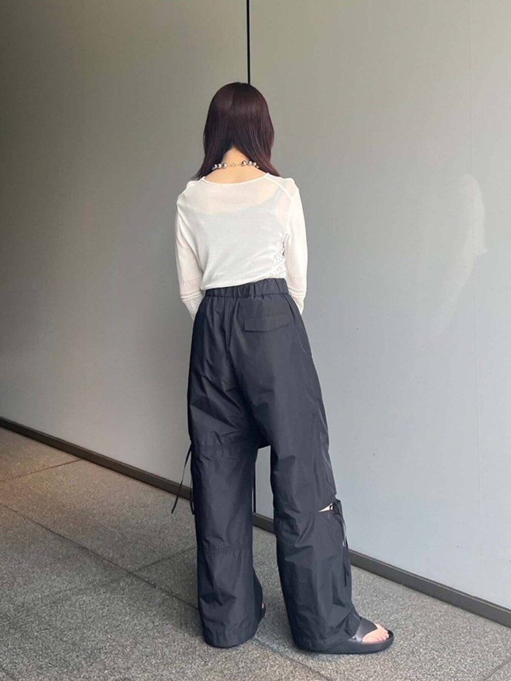 ホワイト系のニット/セーター、ブラック系のその他パンツを着用したレディースの夏コーディネートの3枚目の写真