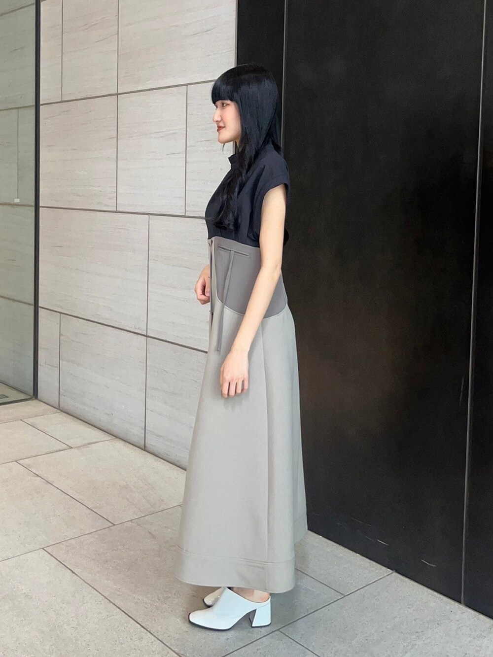 ブラック系のワンピースを着用したレディースの春コーディネートの2枚目の写真