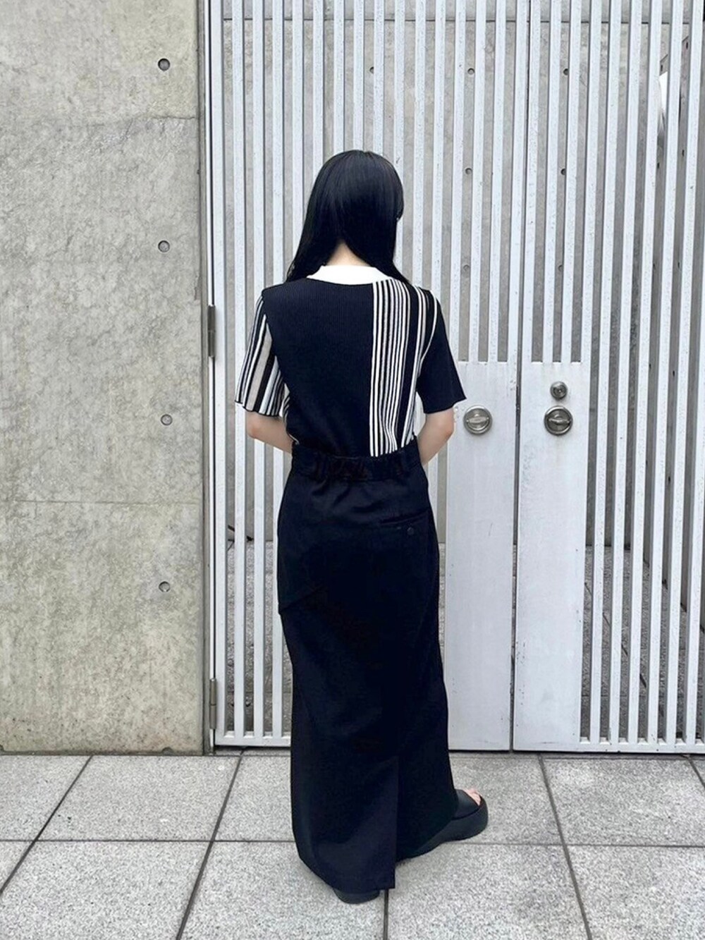 ブラック系のニット/セーター、ブラック系のスカートを着用したレディースの春コーディネートの3枚目の写真