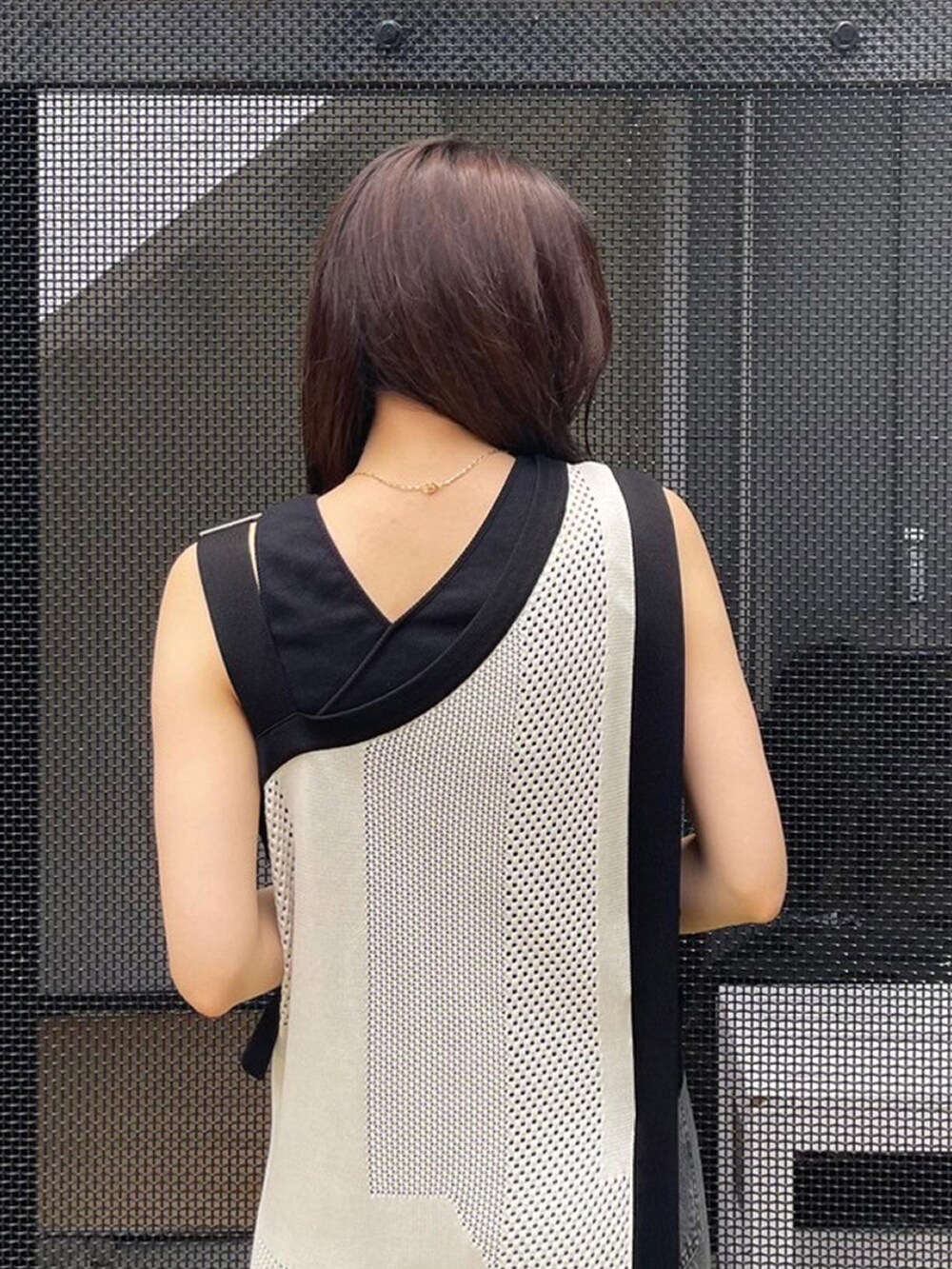 ホワイト系のワンピース、ブラック系のタンクトップ、ブラック系のデニムパンツを着用したレディースの春コーディネートの6枚目の写真