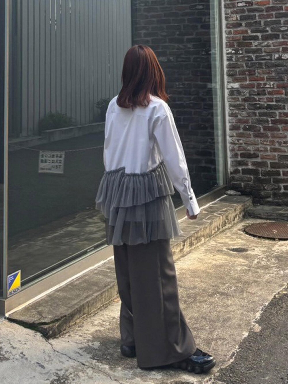 グレー系のシャツ/ブラウス、ブラウン系のその他パンツを着用したレディースの秋コーディネートの2枚目の写真