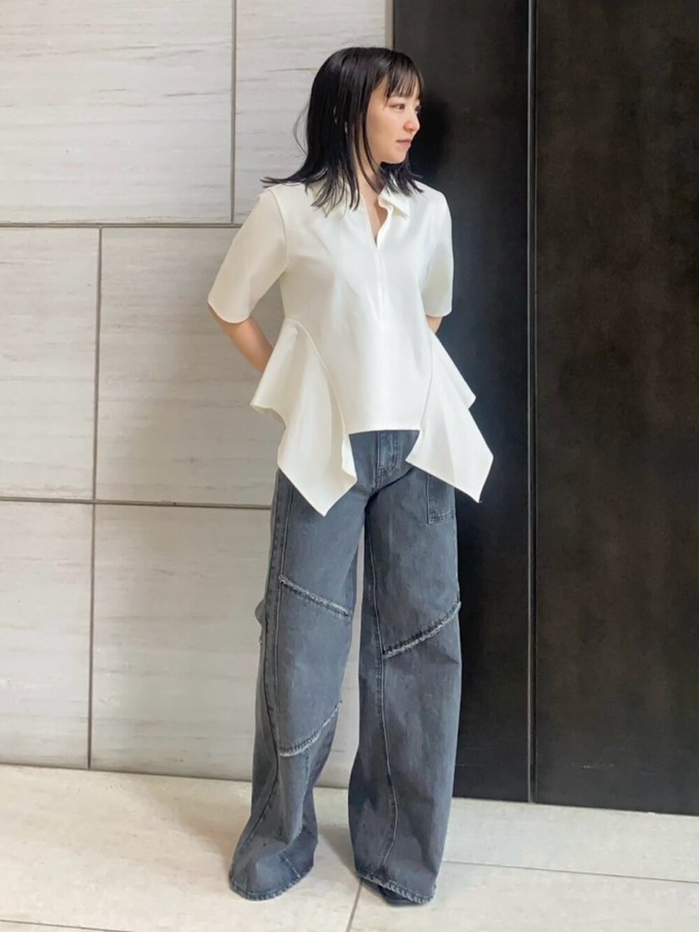 ベージュ系のTシャツ/カットソー、ブラック系のデニムパンツを着用したレディースの春コーディネートの2枚目の写真