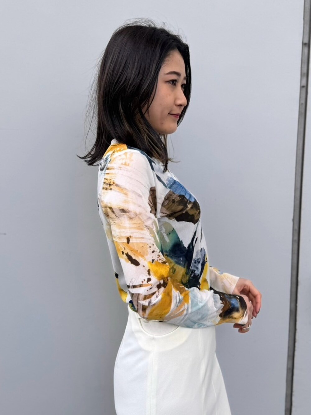 イエロー系のTシャツ/カットソー、ホワイト系のスカートを着用したレディースの冬コーディネートの7枚目の写真