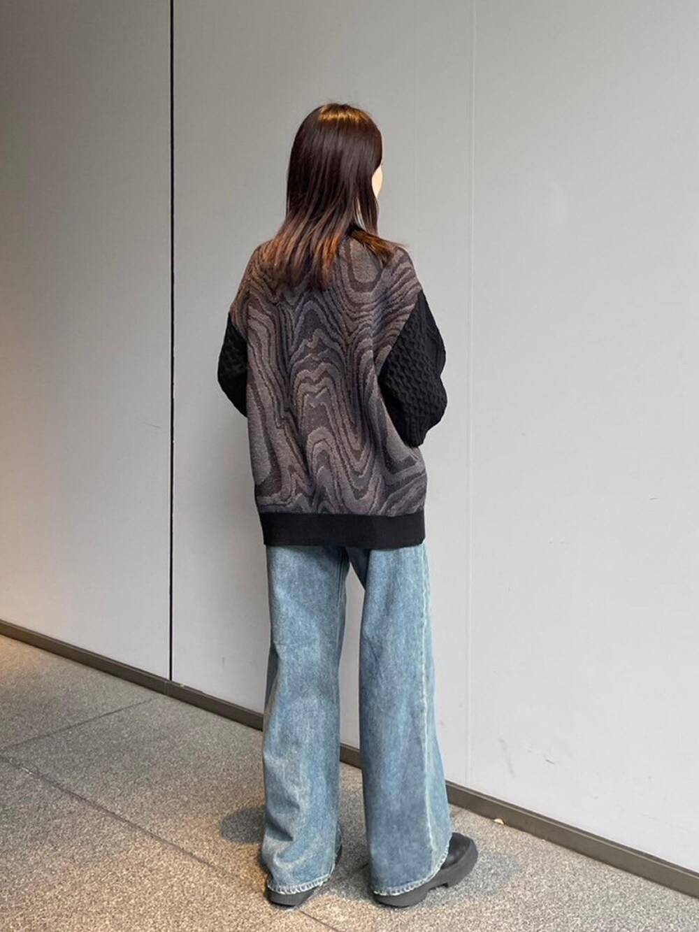 ブラック系のニット/セーター、ブルー系のデニムパンツを着用したレディースの秋コーディネートの3枚目の写真