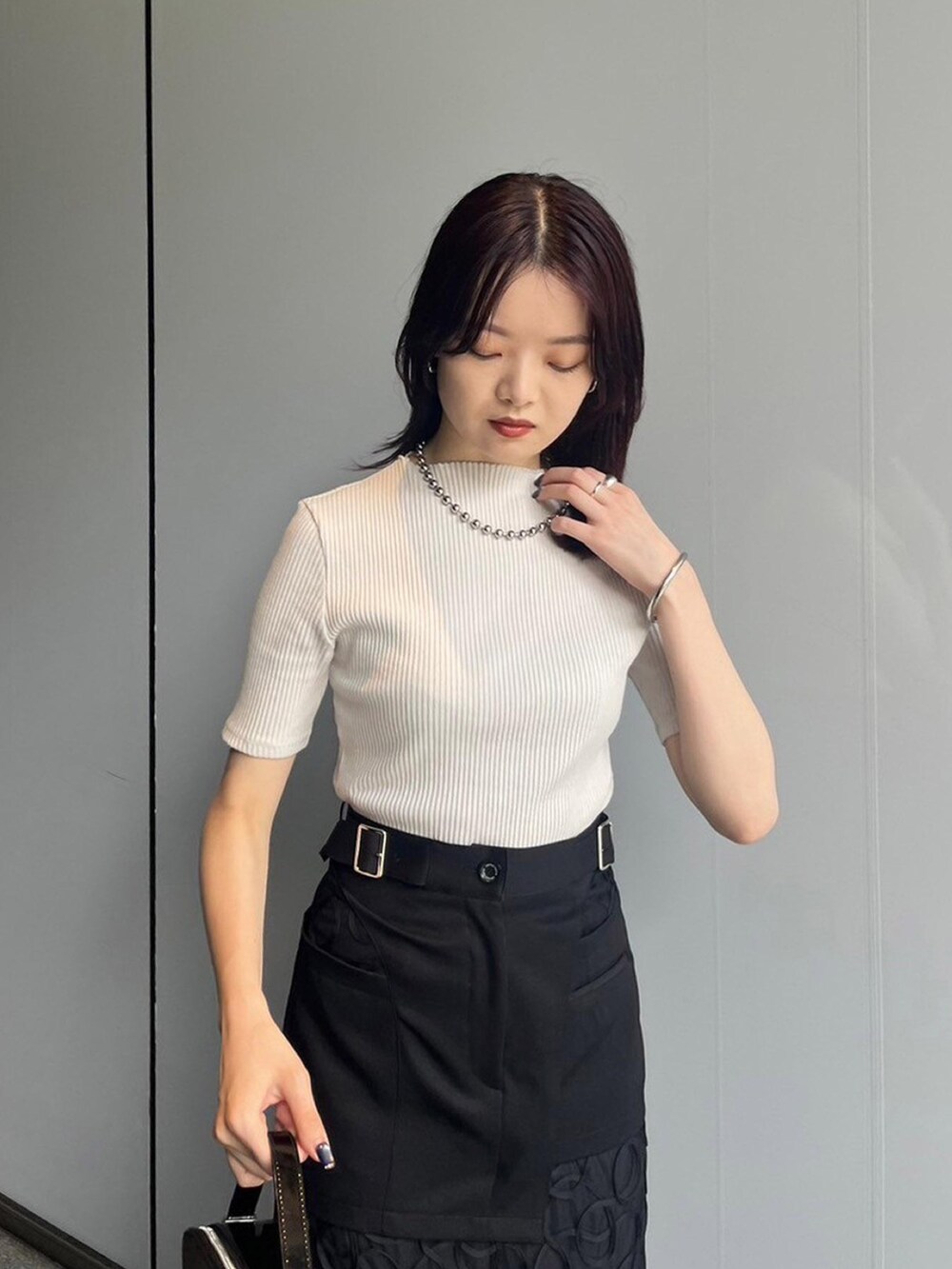 ホワイト系のTシャツ/カットソー、ブラック系のスカート、ブラック系のサンダルを着用したレディースの夏コーディネートの3枚目の写真