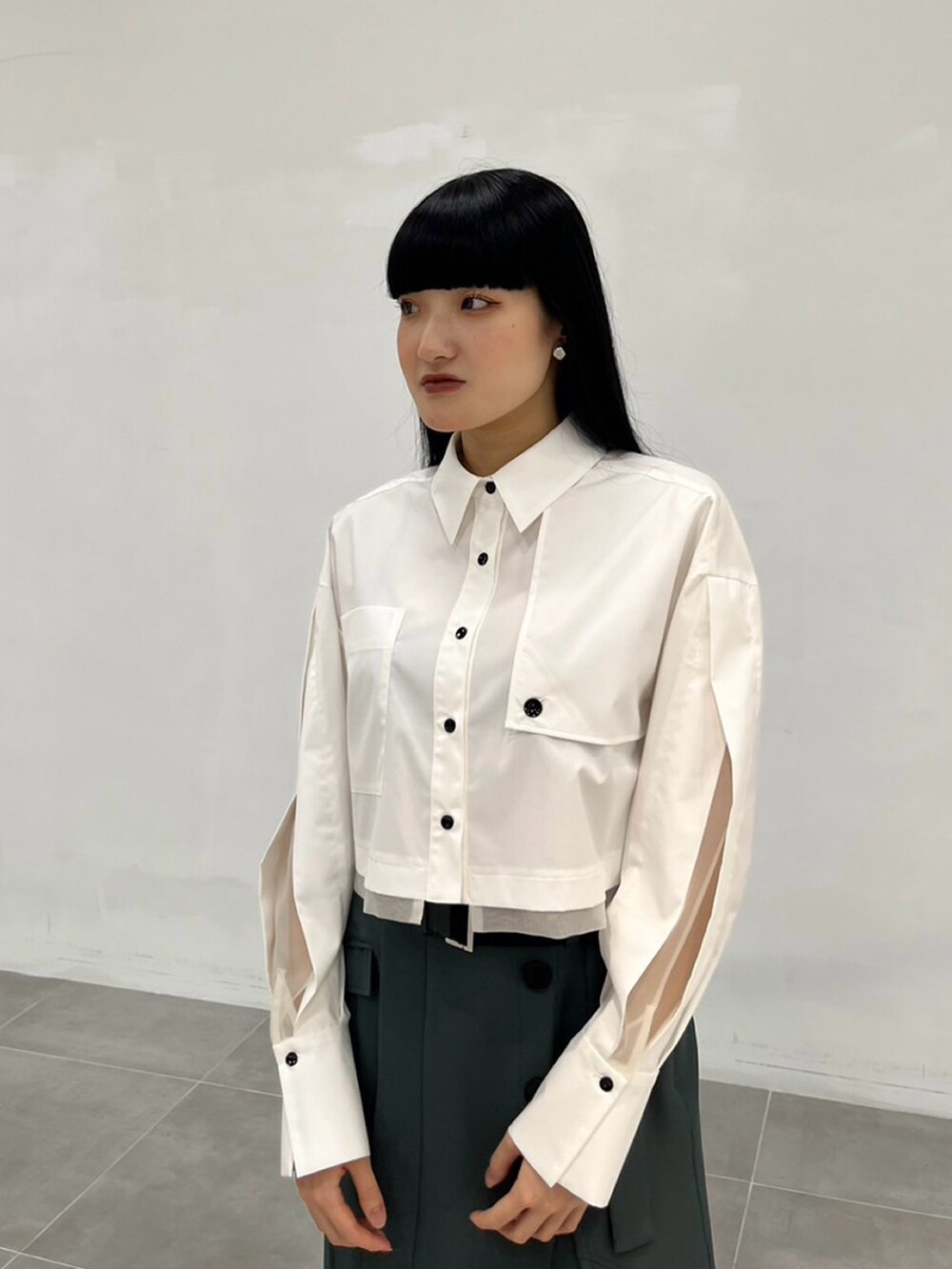 ホワイト系のシャツ/ブラウス、グリーン系のスカートを着用したレディースの秋コーディネートの3枚目の写真