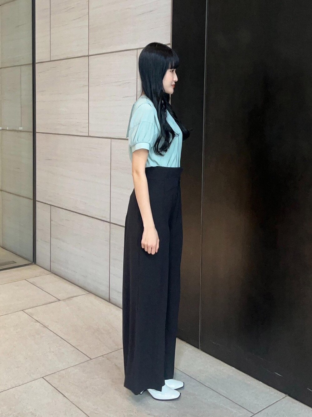 ブラック系のスラックス、グリーン系のシャツ/ブラウスを着用したレディースの春コーディネートの4枚目の写真