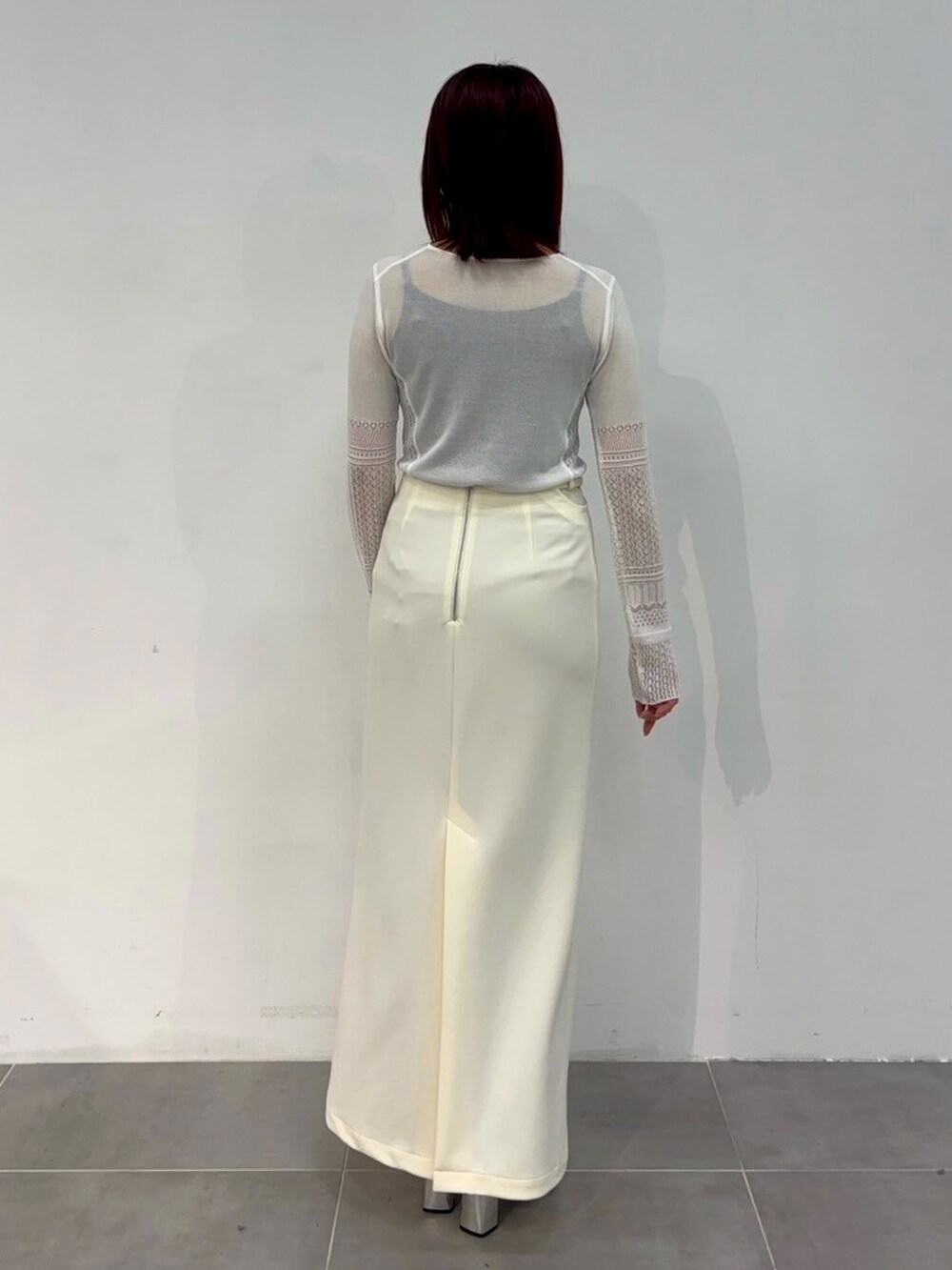 ホワイト系のニット/セーター、ホワイト系のスカートを着用したレディースの春コーディネートの3枚目の写真