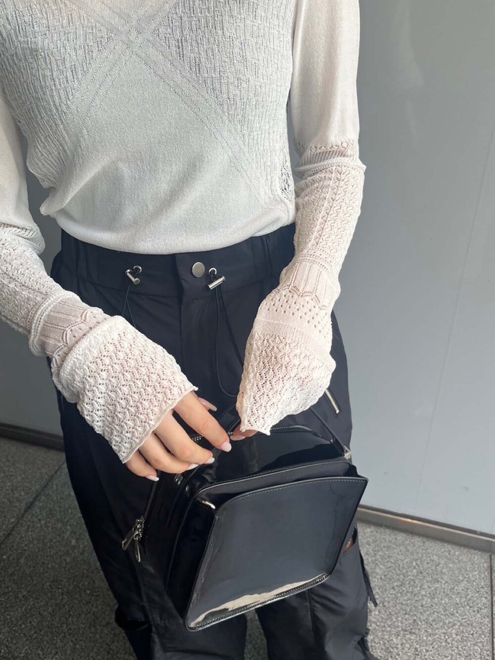 ホワイト系のニット/セーター、ブラック系のその他パンツを着用したレディースの夏コーディネートの5枚目の写真