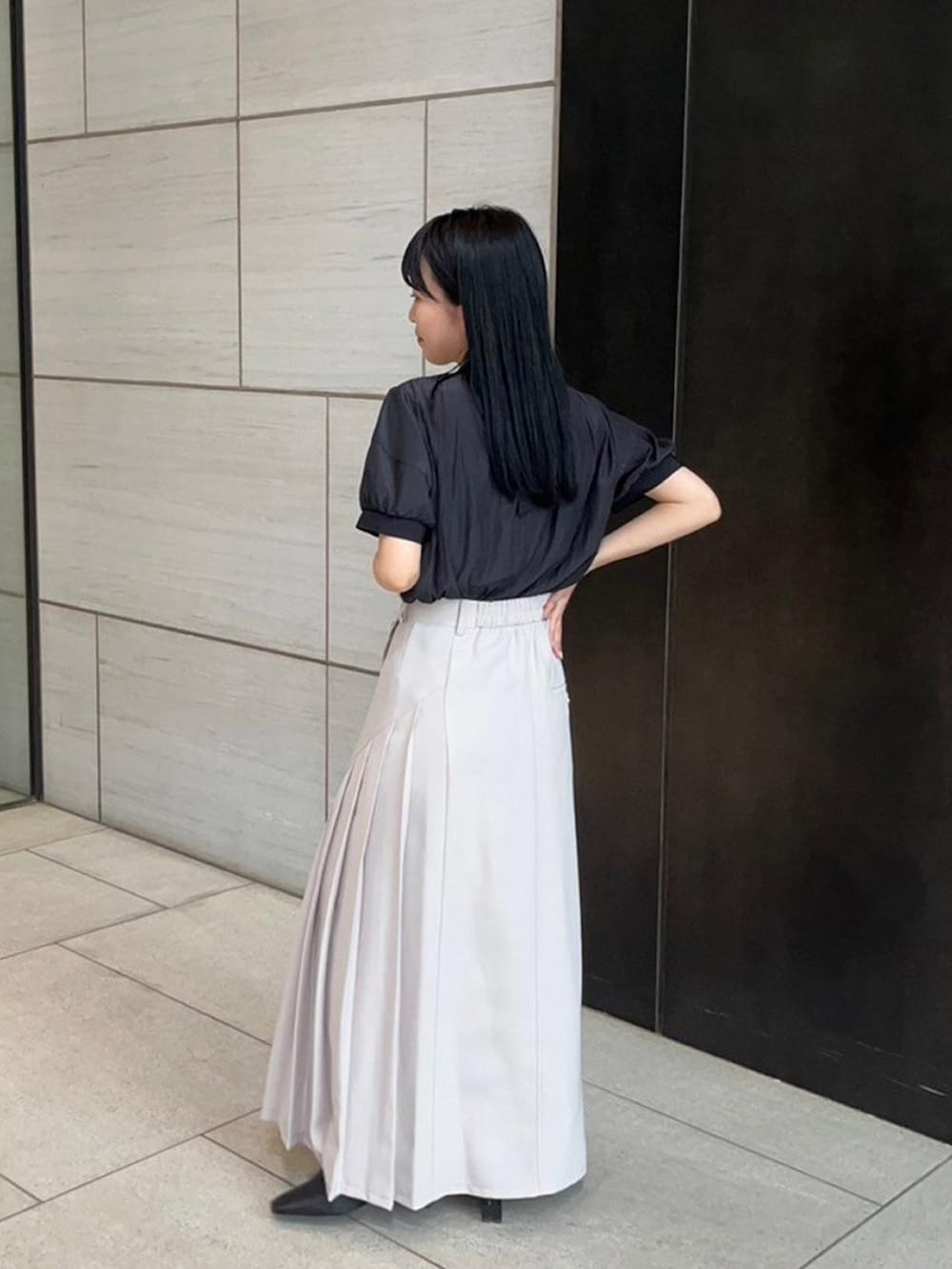 ベージュ系のスカート、ブラック系のシャツ/ブラウスを着用したレディースの春コーディネートの3枚目の写真