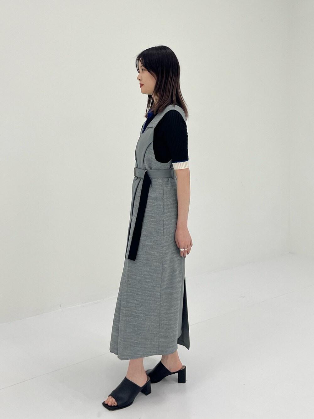 グレー系のジャンパースカート、ブラック系のニット/セーターを着用したレディースの夏コーディネートの3枚目の写真