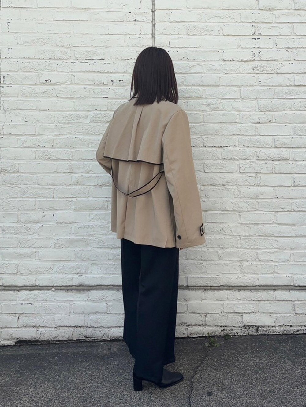 ベージュ系のトレンチコートを着用したレディースの春コーディネートの3枚目の写真