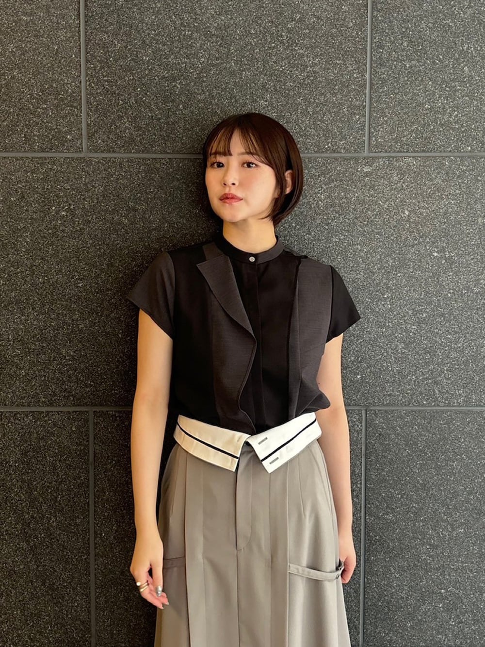 ブラック系のシャツ/ブラウス、グレー系のスカート、ブラック系のサンダルを着用したレディースの夏コーディネートの3枚目の写真