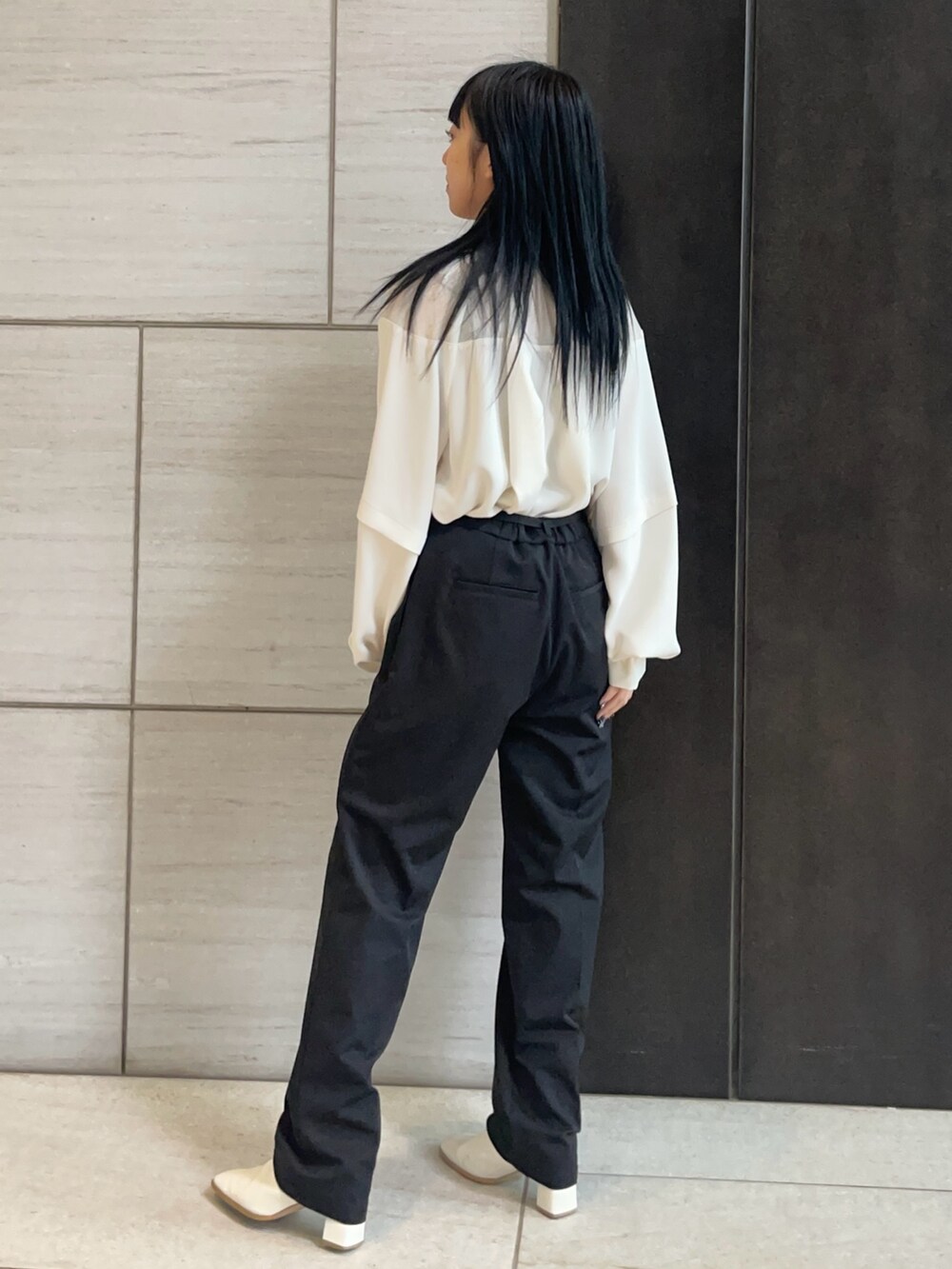 ホワイト系のシャツ/ブラウス、ブラック系のスラックスを着用したレディースの春コーディネートの2枚目の写真