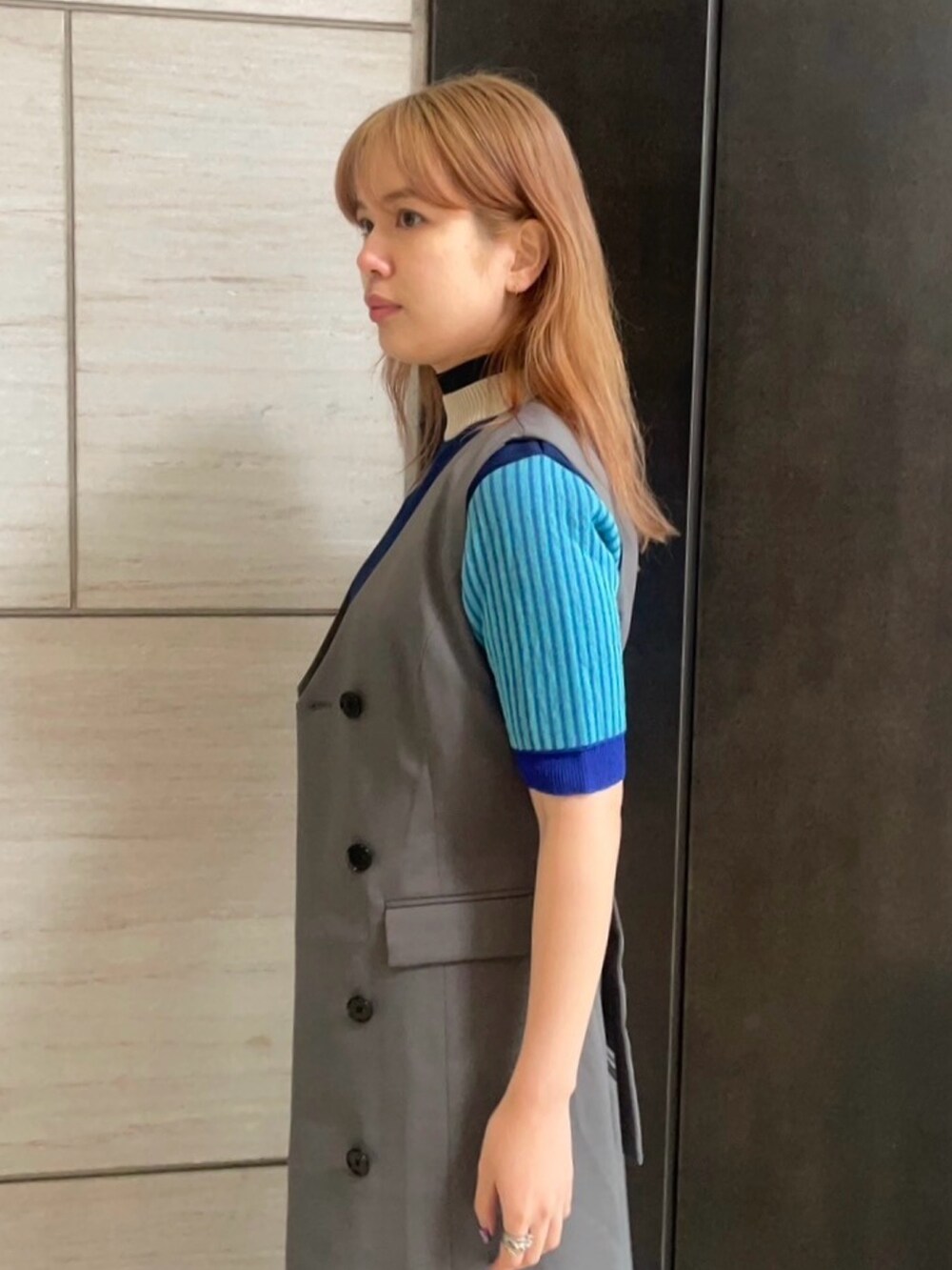 グレー系のジャンパースカートを着用したレディースの春コーディネートの5枚目の写真