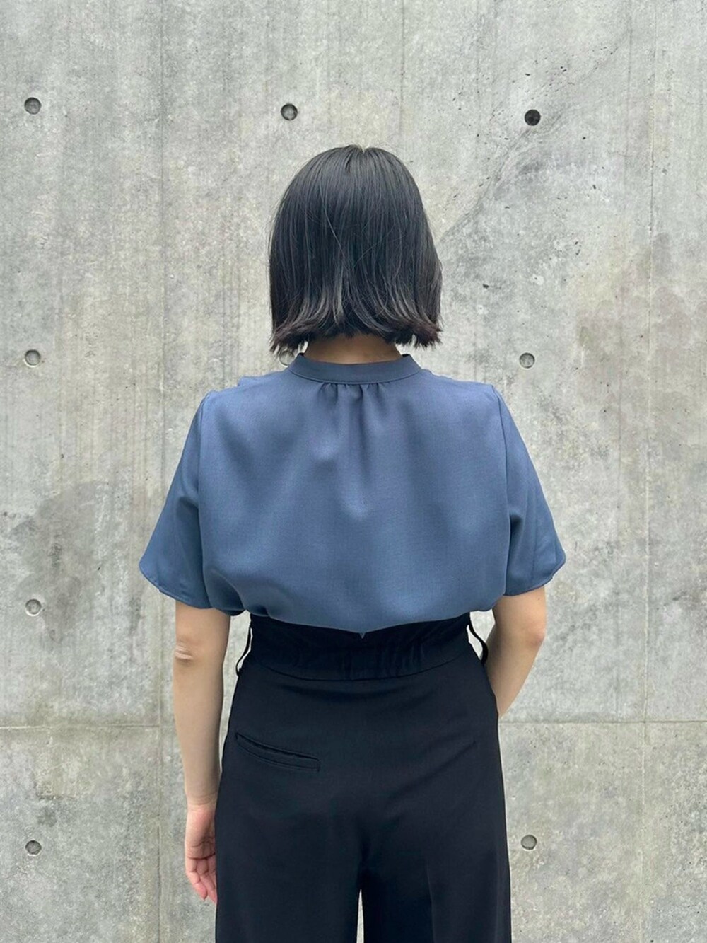 ブルー系のシャツ/ブラウス、ブラック系のスラックスを着用したレディースの春コーディネートの6枚目の写真