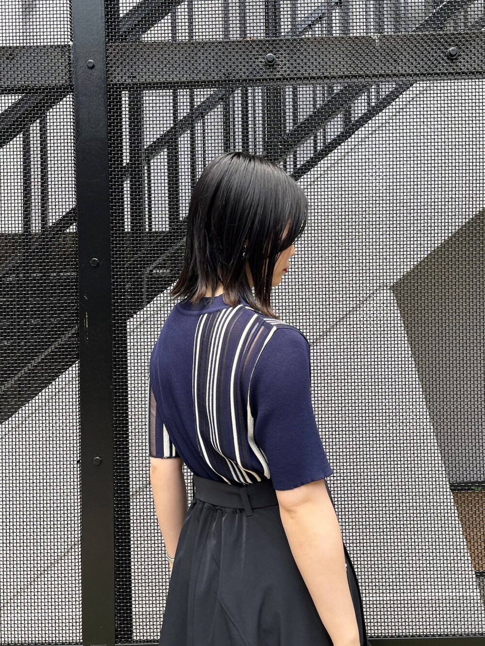 ブルー系のニット/セーター、ブラック系のスカートを着用したレディースの春コーディネートの5枚目の写真