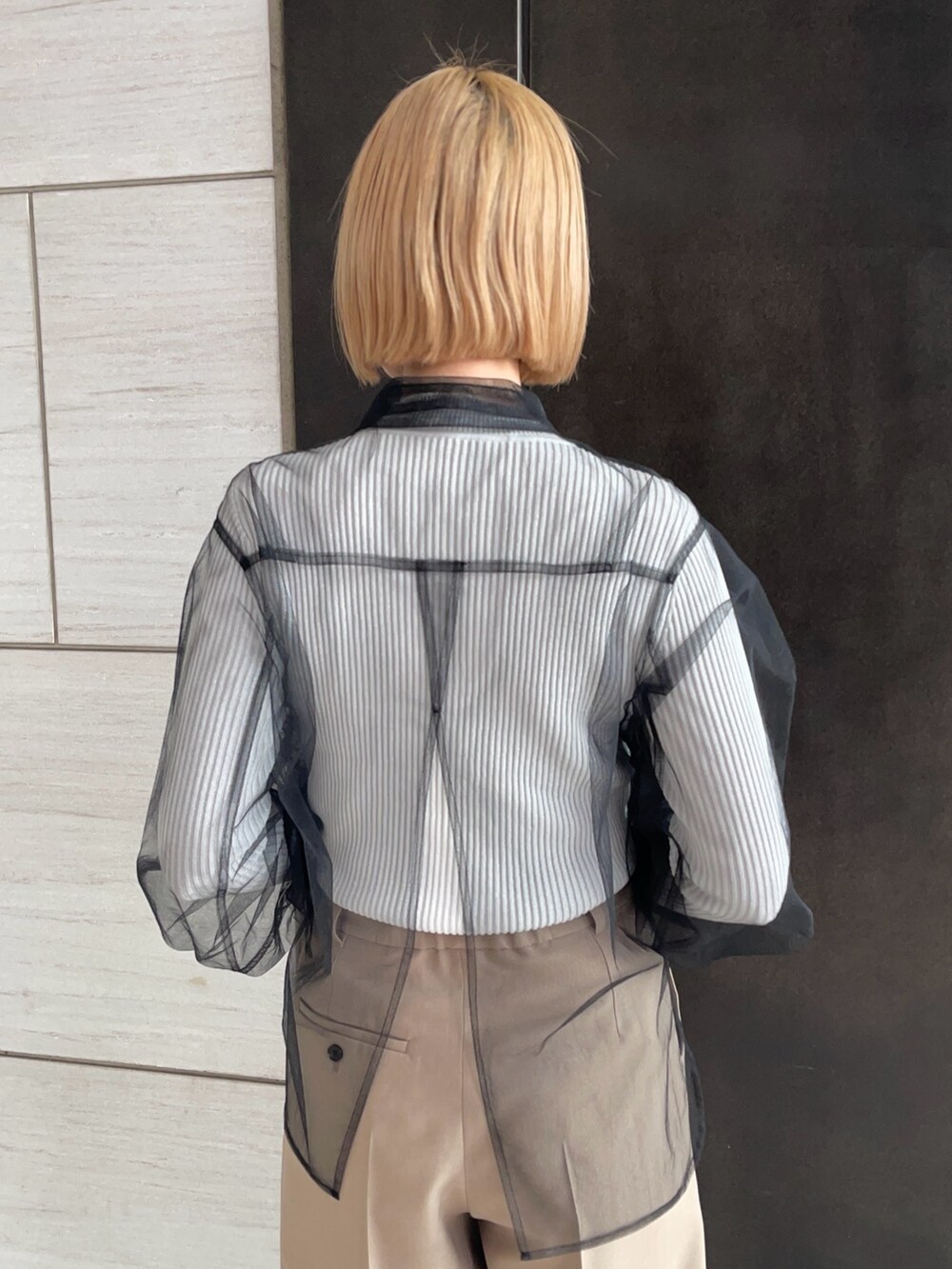 ブラック系のシャツ/ブラウス、ホワイト系のニット/セーター、ベージュ系のその他パンツを着用したレディースの春コーディネートの7枚目の写真