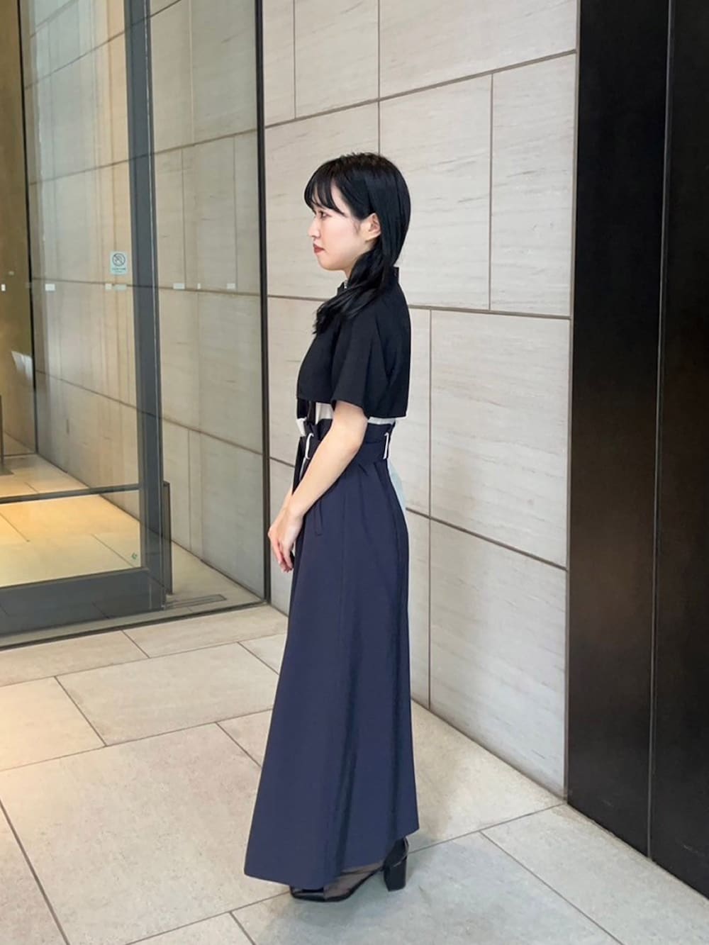 ブラック系のワンピースを着用したレディースの春コーディネートの2枚目の写真