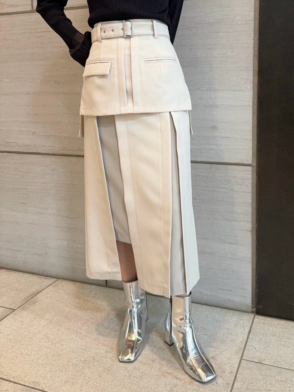 ベージュ系のスカート、ブラック系のニット/セーターを着用したレディースの春コーディネートの4枚目の写真