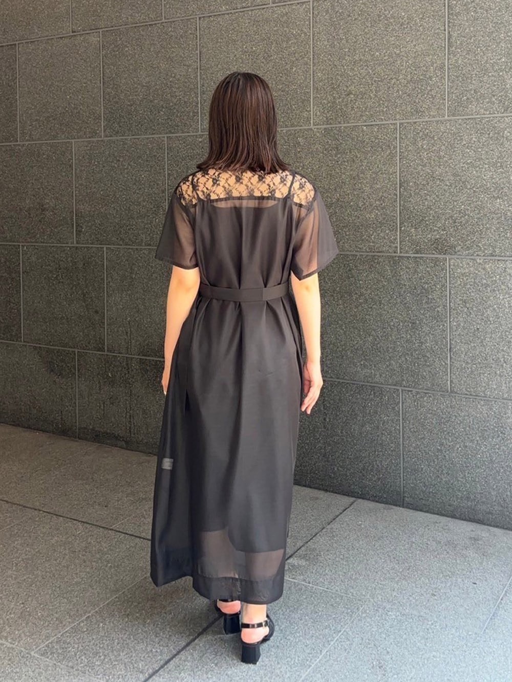 ブラック系のシャツワンピースを着用したレディースの夏コーディネートの2枚目の写真