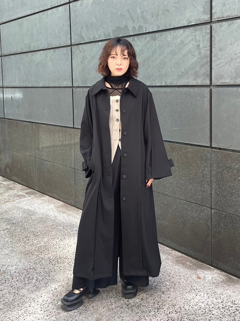 ブラック系のトレンチコートを着用したレディースの秋コーディネートの3枚目の写真