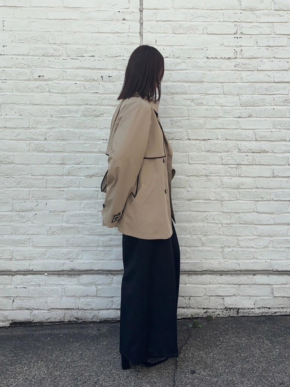 ベージュ系のトレンチコートを着用したレディースの春コーディネートの4枚目の写真