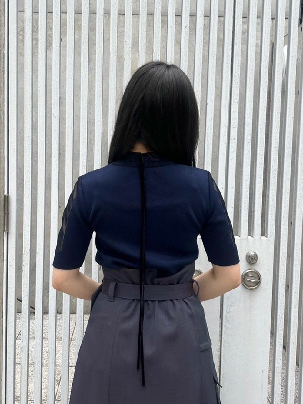 ブルー系のニット/セーターを着用したレディースの春コーディネートの6枚目の写真